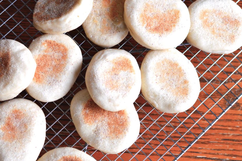 top view of several English muffins piled on a metal dry rack