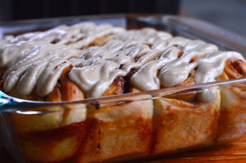side view of baked cinnamon rolls with creamy cashew drizzle on top