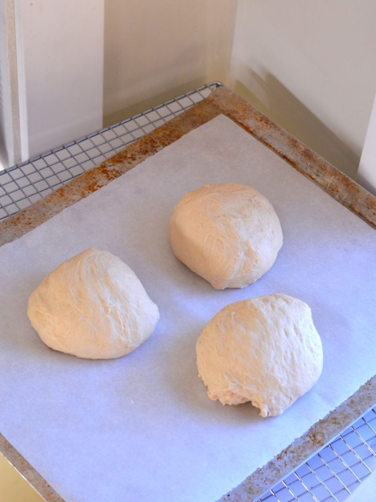 three balls of dough on a tray