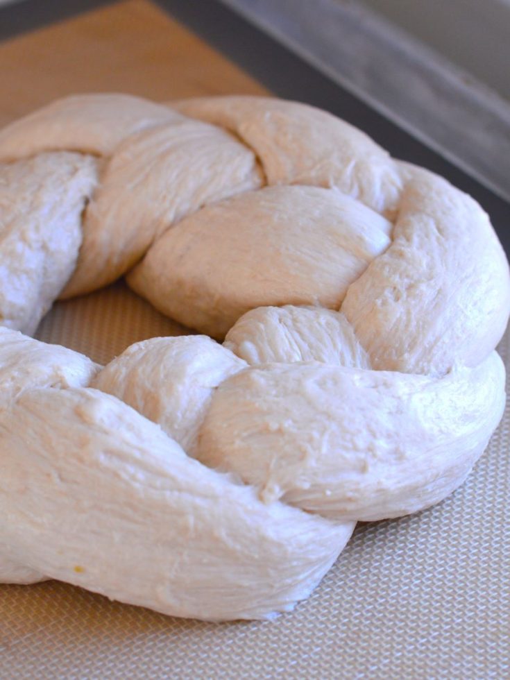 braided bread dough on baking sheet lined with silicone mat