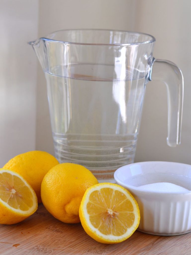 Pitcher of water next to lemons and bowl of monk fruit/erythritol blend