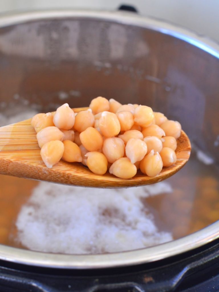 wooden spoon of cooked chickpeas