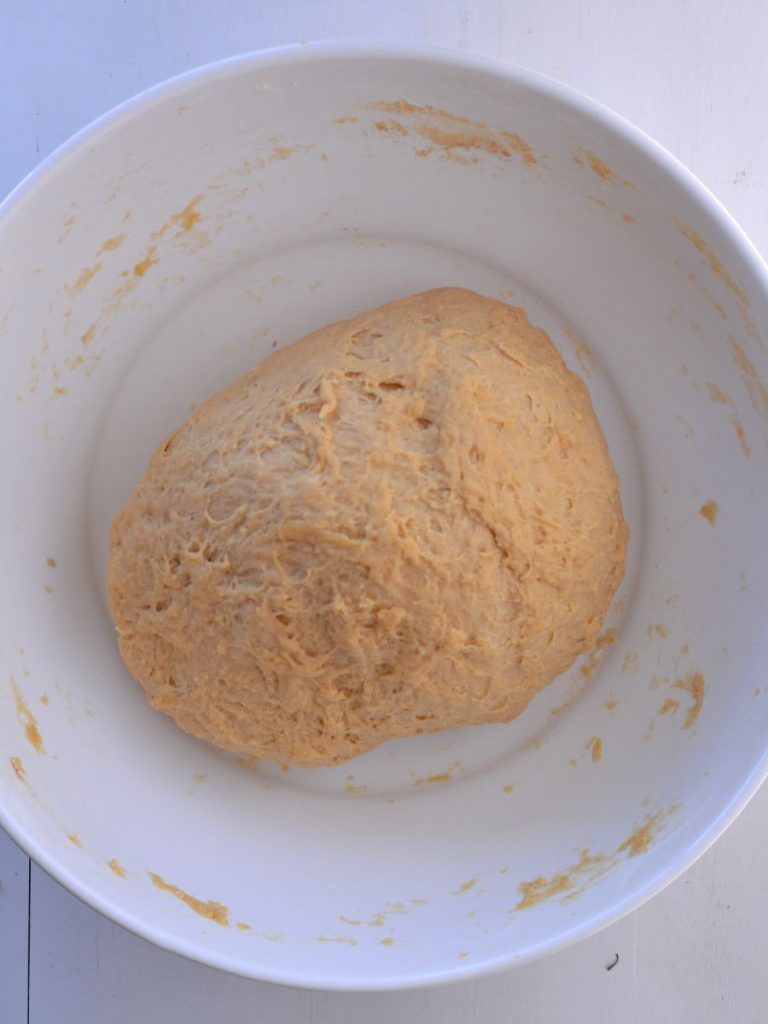 unrisen ball of roll dough in bowl.